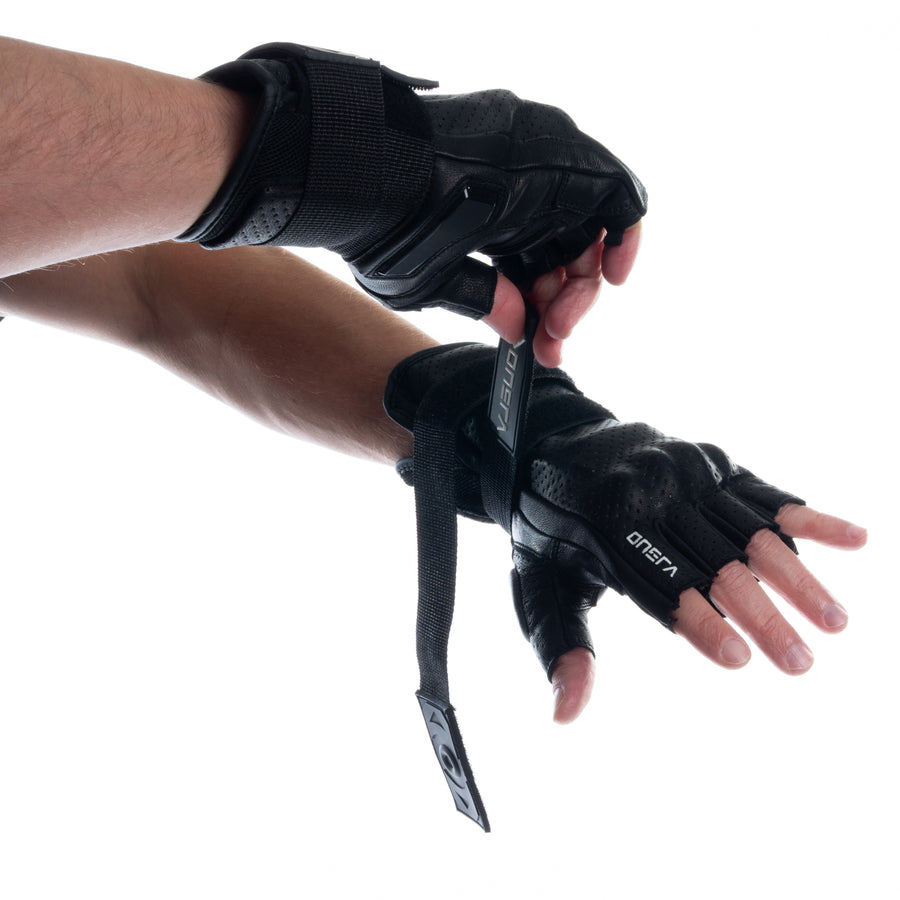 Putting on a pair of black ONSRA short-finger e-skate gloves with wrist straps
